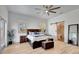 Bright main bedroom with light wood floors, stylish furniture, and an ensuite bathroom behind a sliding door at 217 22Nd Street Ne Ct, Bradenton, FL 34208