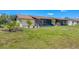 Well-manicured backyard with lush green grass and a beautiful screened-in lanai attached to the home at 217 High Point Dr # 217A, Englewood, FL 34223