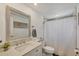 Neutral bathroom featuring a quartz countertop vanity, silver framed mirror, and a white shower with glass doors at 217 High Point Dr # 217A, Englewood, FL 34223