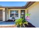 Charming front entrance with a welcome flag, decorative plants, and a window at 217 High Point Dr # 217A, Englewood, FL 34223