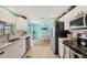 Well-lit kitchen with white cabinets, stainless appliances, and access to the dining area at 217 High Point Dr # 217A, Englewood, FL 34223