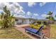 Backyard featuring a patio with seating, lush landscaping, a sun lounger, and verdant tropical foliage at 2402 33Rd W St, Bradenton, FL 34205