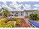 Landscaped backyard with patio and seating, complemented by lush tropical foliage and a well-maintained lawn at 2402 33Rd W St, Bradenton, FL 34205