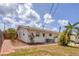 Home exterior with a well-maintained yard, brick walkways, and flourishing trees and tropical landscaping at 2402 33Rd W St, Bradenton, FL 34205