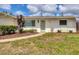 Close-up of the home's facade with a tidy lawn, well kept garden bed, and welcoming front door at 2402 33Rd W St, Bradenton, FL 34205