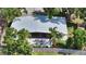 An aerial view of a single-story home featuring a large patio with modern outdoor furniture and lush landscaping at 2516 Goldenrod St, Sarasota, FL 34239