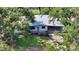 Aerial shot showcases a home with mature trees, a well-manicured lawn, and a covered carport at 2516 Goldenrod St, Sarasota, FL 34239