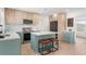 Updated kitchen with stainless steel appliances, a center island with bar stools, and modern cabinetry at 2715 Herwald St, Sarasota, FL 34231