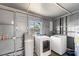 Laundry room with white washer and dryer, water softener, and ample space at 2715 Herwald St, Sarasota, FL 34231