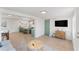 Open-concept living room with eat-in kitchen, light wood floors, and a sliding barn door at 2715 Herwald St, Sarasota, FL 34231