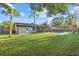 Lush green backyard featuring a refreshing swimming pool, screened-in porch, and well-maintained lawn at 2915 Woodpine Cir, Sarasota, FL 34231