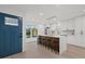 Modern kitchen featuring an island with seating, white cabinets, and a view from the front door at 2915 Woodpine Cir, Sarasota, FL 34231