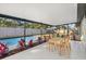 A screened patio featuring a dining area with a view of the sparkling pool and landscaped backyard at 2915 Woodpine Cir, Sarasota, FL 34231