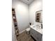 Cozy powder room with a modern vanity, stylish mirror, and rustic shelving at 33 S Palm Ave # 1202, Sarasota, FL 34236