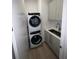 Modern laundry room featuring a stacked washer and dryer unit, sink, and sleek cabinetry at 33 S Palm Ave # 1202, Sarasota, FL 34236