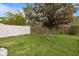 Large backyard with lush grass, a mature tree, and a mix of white vinyl and wood fencing for privacy at 3910 77Th E Pl, Sarasota, FL 34243
