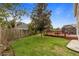 Spacious backyard with lush green grass, wooden fence, deck, and mature trees providing shade and privacy at 3910 77Th E Pl, Sarasota, FL 34243