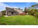 Spacious backyard with lush green lawn, wooden deck, and screened-in patio at 3910 77Th E Pl, Sarasota, FL 34243