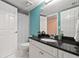 Bright bathroom featuring white vanity, black granite countertop, framed mirror, and shower/tub with white shower curtain at 3910 77Th E Pl, Sarasota, FL 34243