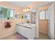 Bathroom with double sink vanity, neutral colors and a brightly lit window at 3910 77Th E Pl, Sarasota, FL 34243