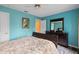Light-filled bedroom with bright blue walls, a sleigh bed, dark wood dresser, ceiling fan and a colorful rug at 3910 77Th E Pl, Sarasota, FL 34243
