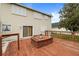 View of spacious wood deck featuring built in seating and sliding door access to the home's interior at 3910 77Th E Pl, Sarasota, FL 34243