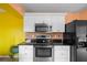 Bright kitchen features black appliances, black counters, and white cabinets at 3910 77Th E Pl, Sarasota, FL 34243
