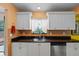 Bright kitchen features white cabinets, stainless steel appliances, and a window at 3910 77Th E Pl, Sarasota, FL 34243