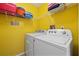 Bright laundry room with white appliances and shelving for storage solutions at 3910 77Th E Pl, Sarasota, FL 34243