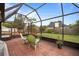 Spacious screened-in patio with view of the large backyard and wooden deck at 3910 77Th E Pl, Sarasota, FL 34243
