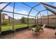 Relaxing screened patio with comfortable seating and view of the green backyard at 3910 77Th E Pl, Sarasota, FL 34243