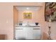 Convenient wet bar area with modern white cabinetry, sink, and a countertop for entertaining at 3910 77Th E Pl, Sarasota, FL 34243