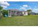 Expansive backyard featuring lush green grass, screened-in lanai, and ample room for outdoor activities at 4103 61St E Ave, Bradenton, FL 34203