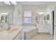 This bathroom has a soaking tub, double sink vanities, and beautiful tile flooring throughout at 4103 61St E Ave, Bradenton, FL 34203