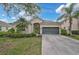 Charming single-story home with a gray two-car garage, lush landscaping, and a well-manicured lawn in a sunny neighborhood at 4103 61St E Ave, Bradenton, FL 34203