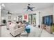 Bright living room featuring tile flooring, neutral paint, large windows, and a modern ceiling fan at 4103 61St E Ave, Bradenton, FL 34203