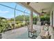 This screened patio features a comfortable seating area and a serene view of the water and landscape at 4103 61St E Ave, Bradenton, FL 34203