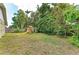 Private backyard with a wooden playset featuring a slide and swing set amidst lush greenery at 4115 2Nd Nw Ave, Bradenton, FL 34209