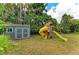Wide backyard with a large playset featuring slides, along with a shed and plenty of room to play at 4115 2Nd Nw Ave, Bradenton, FL 34209