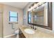 Bathroom with granite counters, dark cabinets, glass shower, and views to the window at 4115 2Nd Nw Ave, Bradenton, FL 34209