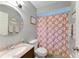 Cozy bathroom featuring a granite vanity, toilet, and tub with cheerful flower curtain at 4115 2Nd Nw Ave, Bradenton, FL 34209