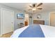 Bedroom boasts wood floors, neutral walls, ceiling fan, tv, and an ensuite bathroom at 4115 2Nd Nw Ave, Bradenton, FL 34209