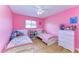 Bright bedroom with two twin beds, colorful decor, ceiling fan, and wood-look flooring at 4115 2Nd Nw Ave, Bradenton, FL 34209