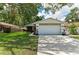 Exterior view of home with a lush green lawn and an attached two-car garage, with a boat and trailer parked on the side at 4115 2Nd Nw Ave, Bradenton, FL 34209