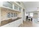 Kitchen highlights granite counters, custom cabinets with glass, tile backsplash, and living room access at 4115 2Nd Nw Ave, Bradenton, FL 34209
