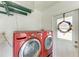 Laundry room with red washer and dryer, and access door to outside at 4115 2Nd Nw Ave, Bradenton, FL 34209