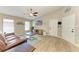 Bright living room with wood-look tile flooring, a ceiling fan, a leather sofa, and neutral wall paint for a comfortable atmosphere at 4115 2Nd Nw Ave, Bradenton, FL 34209