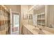 The bathroom features a vanity with a sink and a large mirror with lights above, along with a shower with a curtain at 4274 Tennyson Way, Venice, FL 34293