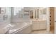 Bright bathroom featuring a large soaking tub, glass block window, and a single sink at 4274 Tennyson Way, Venice, FL 34293