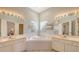 Bathroom featuring dual vanities, framed mirrors, and a large corner soaking tub at 4274 Tennyson Way, Venice, FL 34293